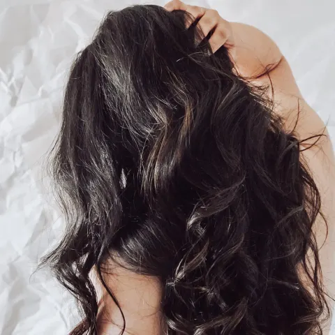 Cabello castaño brillante sobre fondo oscuro